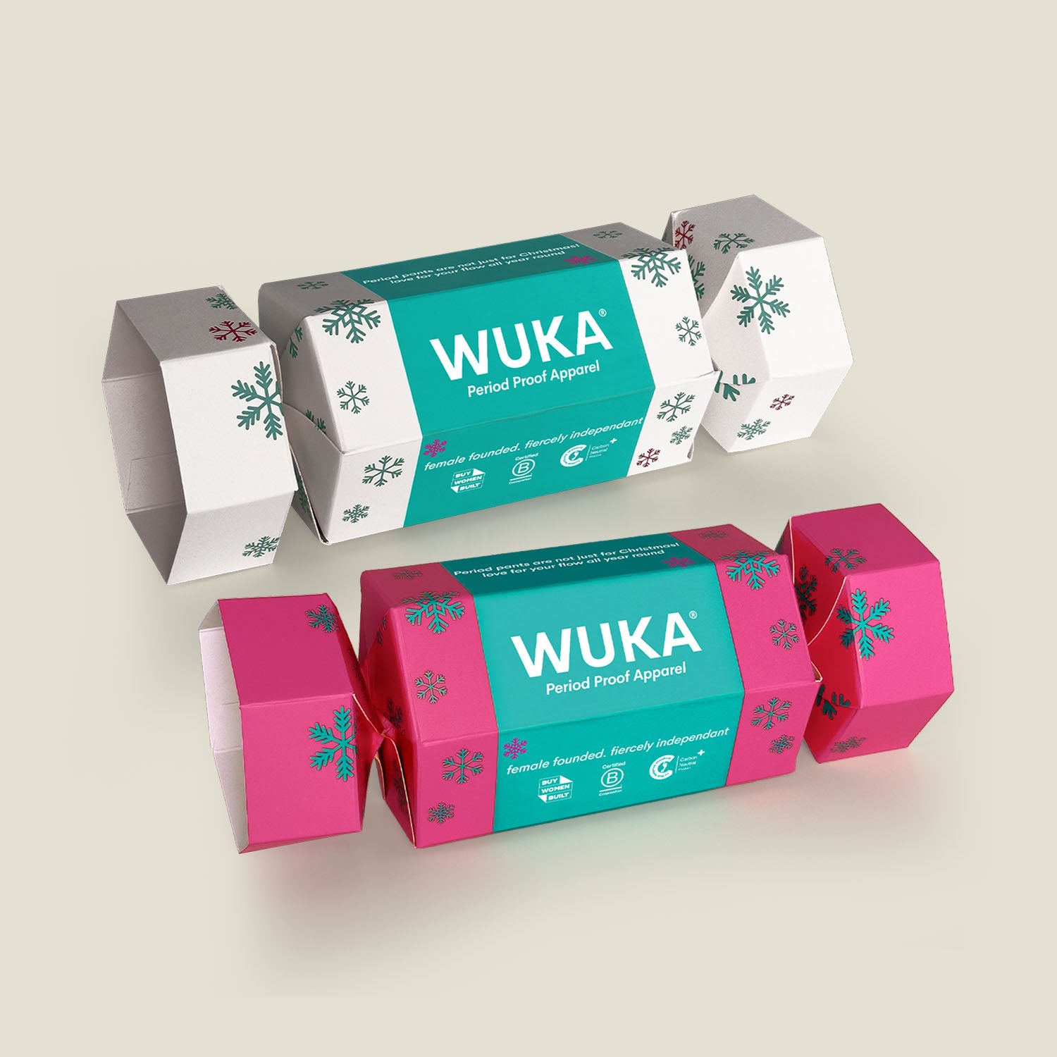 Two WUKA Cracker Gift Boxes – one in pink and the other in white. These festive eco crackers are made from FSC-certified cardboard and filled with sustainable period-proof apparel.