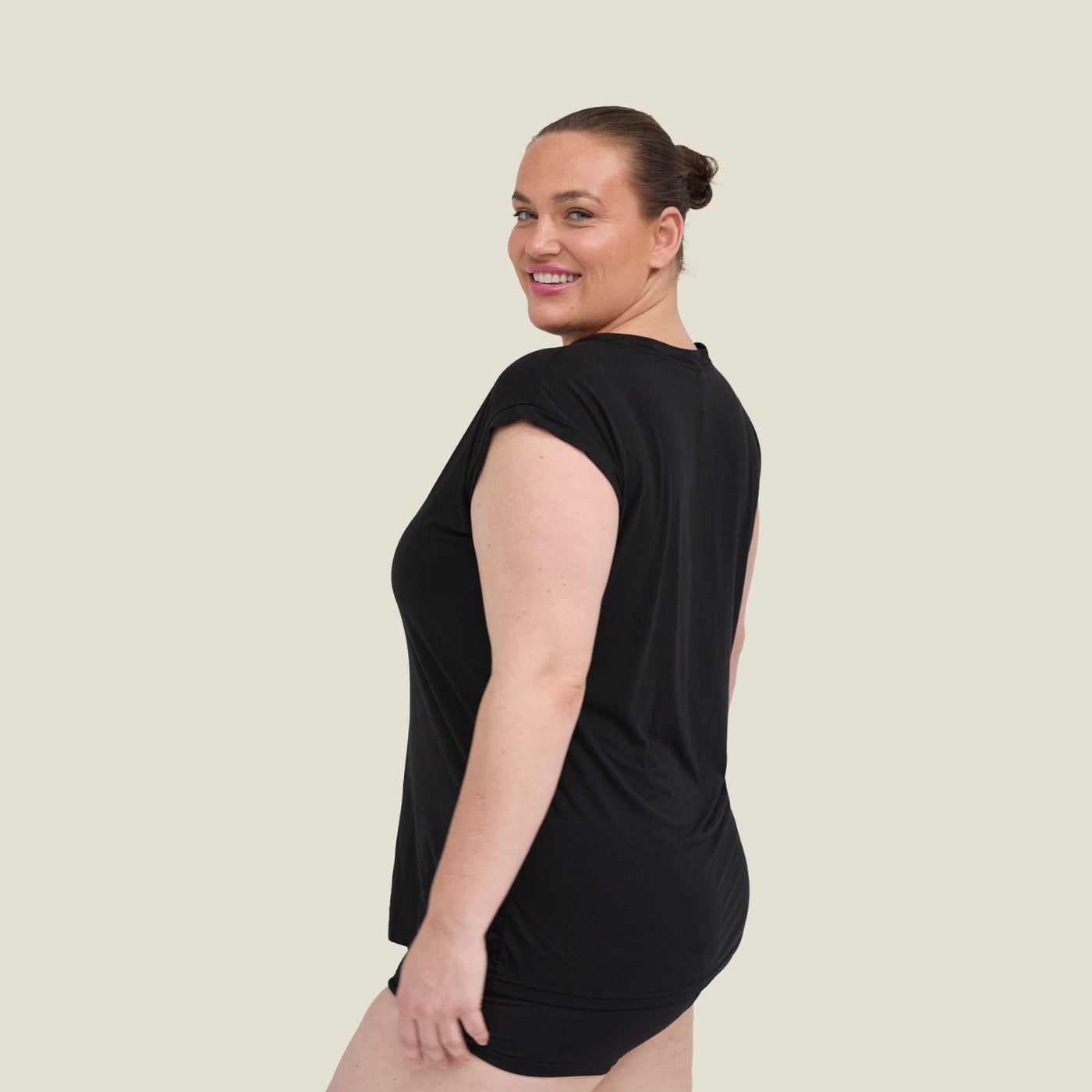 Side angle of black WUKA Pyjama Jersey T-Shirt worn by model, designed for menopause relief with moisture-wicking technology.