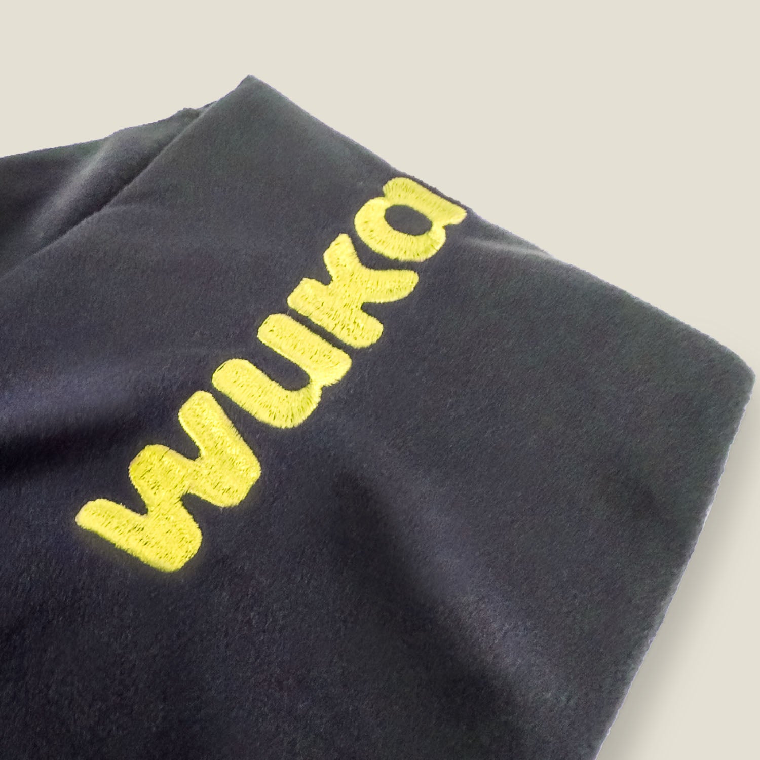 Embroidered WUKA logo on black fleece cover of period hot water bottle